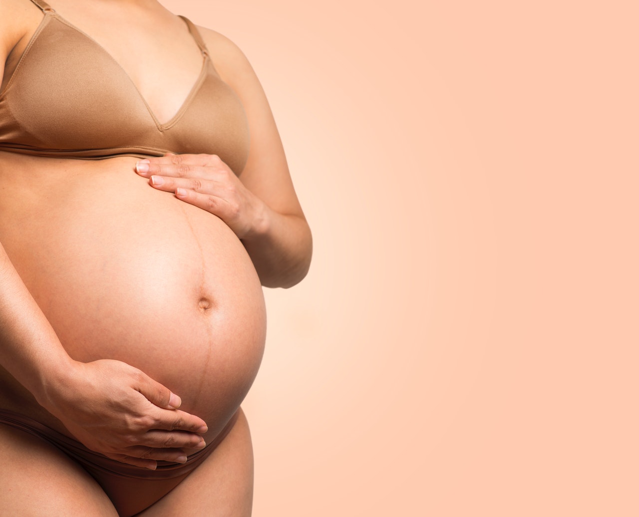 Pregnant woman is holding her belly