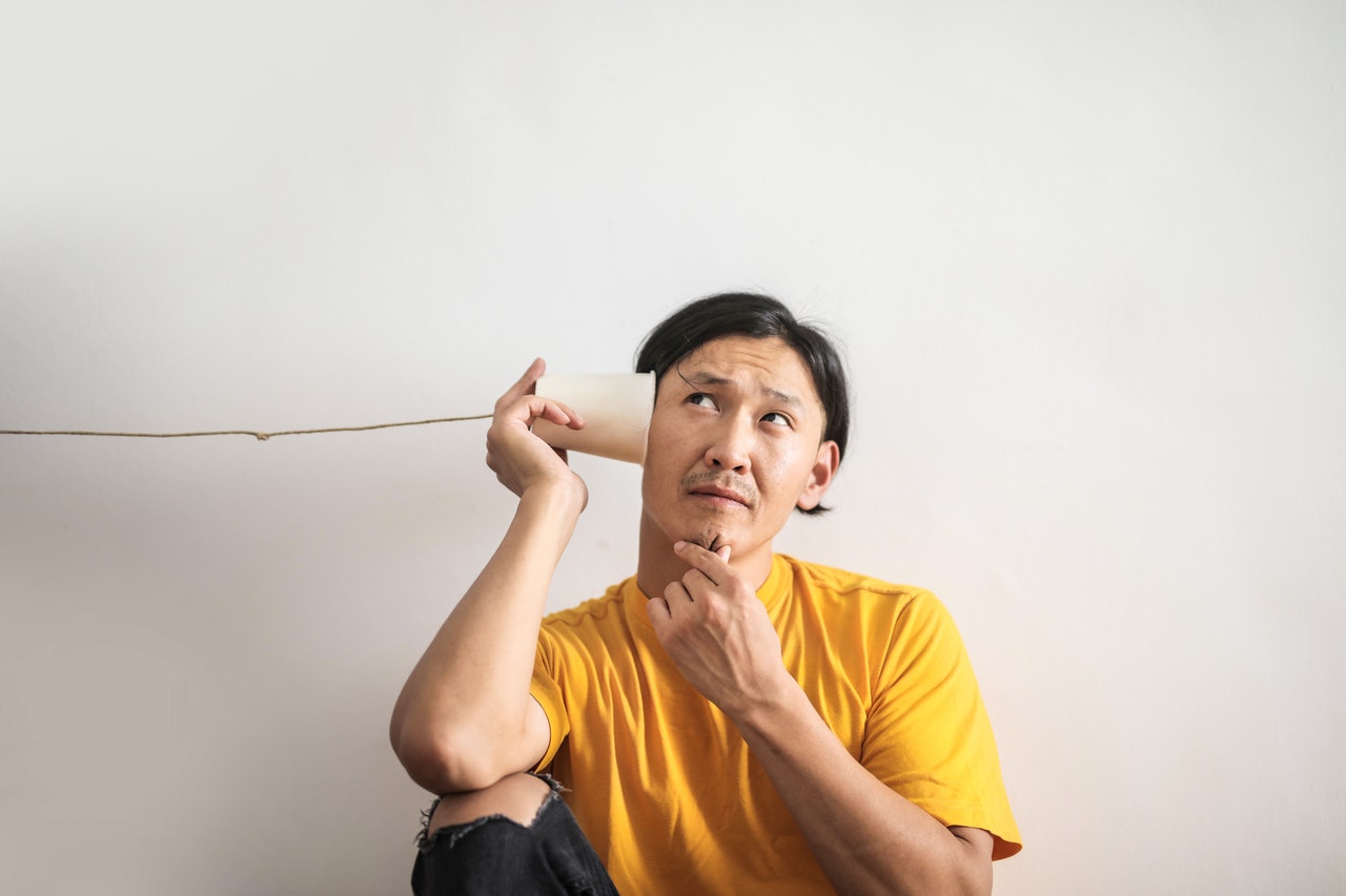 Man is trying to hear something out of cup