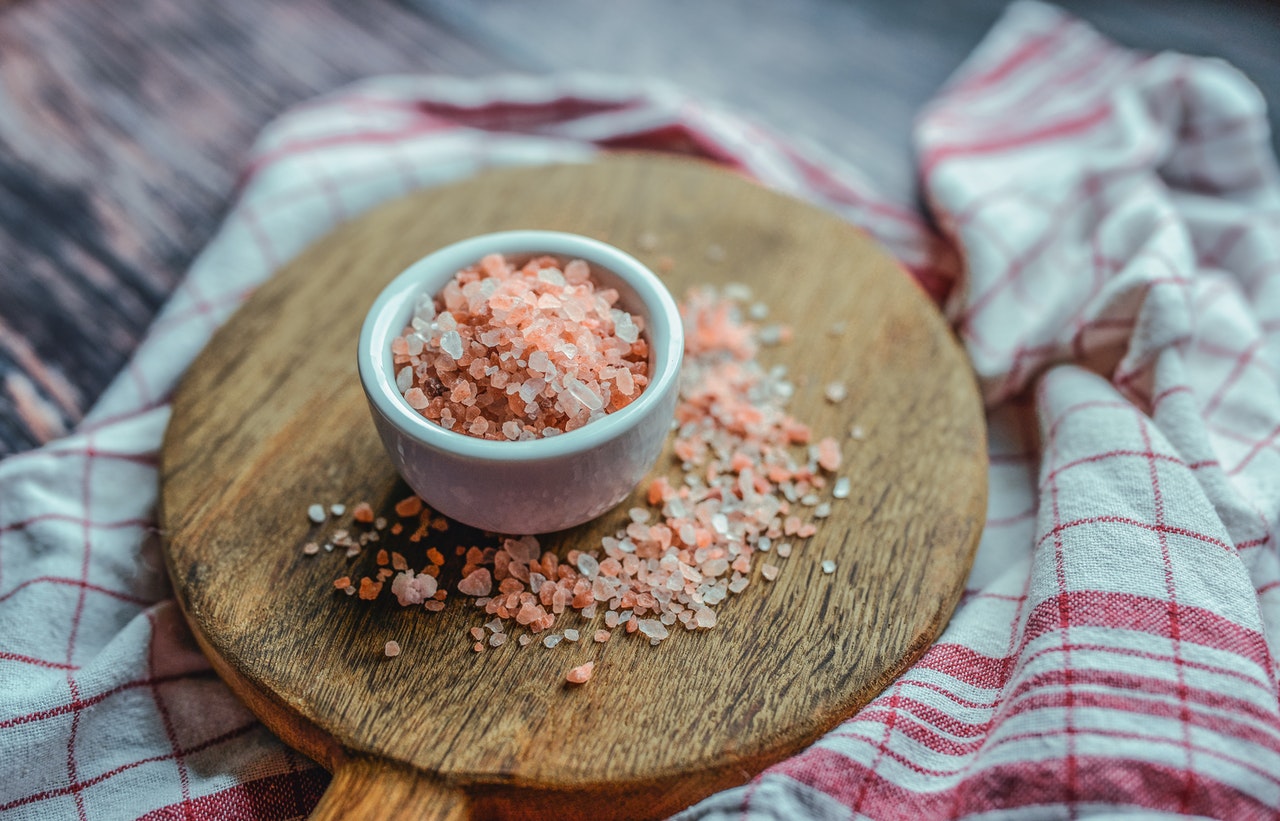 Pink salt in little bowl on wooden stand 